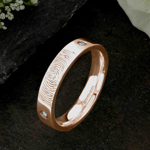 A Rose Gold Wedding Ring with an engraved fingerprint on the outer surface | Set with two diamonds that frame the fingerprint | Hand engraving | Ladies slim 4mm wide, comfort flat-court profile ring | Custom personalised wedding jewellery | Sophia Alexander Fingerprint Jewellery | Handmade in Suffolk UK