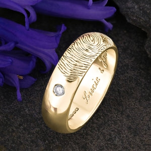 A Gold Wedding Ring with an engraved fingerprint on the outer surface | Set with two diamonds that frame the fingerprint | Engraved with two names on the inside of the ring | Hand engraving | Mens 6mm wide, comfort court profile ring | Custom personalised wedding jewellery | Sophia Alexander Fingerprint Jewellery | Handmade in Suffolk UK