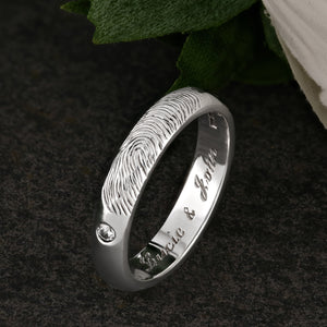 A White Gold Wedding Ring with an engraved fingerprint on the outer surface | Set with two diamonds that frame the fingerprint | Engraved with two names on the inside of the ring | Hand engraving | Ladies slim 4mm wide, comfort court profile ring | Custom personalised wedding jewellery | Sophia Alexander Fingerprint Jewellery | Handmade in Suffolk UK