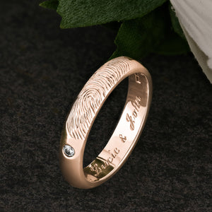 A Rose Gold Wedding Ring with an engraved fingerprint on the outer surface | Set with two diamonds that frame the fingerprint | Engraved with two names on the inside of the ring | Hand engraving | Ladies slim 4mm wide, comfort court profile ring | Custom personalised wedding jewellery | Sophia Alexander Fingerprint Jewellery | Handmade in Suffolk UK