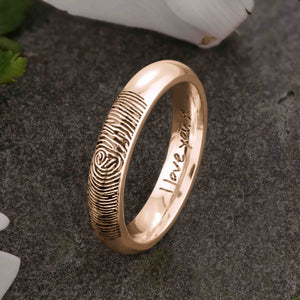 A unique rose or red gold Wedding Ring with an engraved fingerprint on the outer surface | Engraved with a handwritten personal message on the inside of the ring | The engraving reads "I love you. x" | Contemporary dark laser engraving | Ladies slim 4mm wide, comfort court profile ring | Custom personalised wedding jewellery | Sophia Alexander Fingerprint Jewellery | Handmade in Suffolk UK