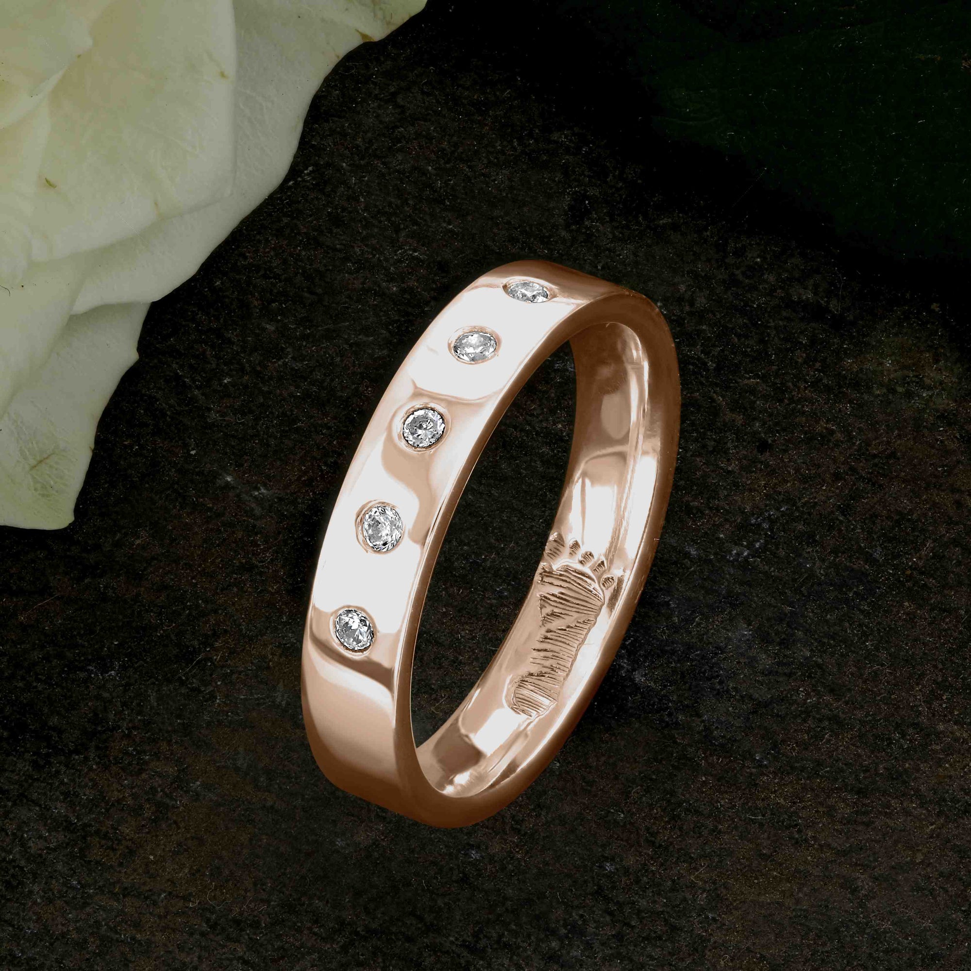 A Rose Gold Wedding Ring with an engraved baby footprint on the inside surface | Set with five beautiful diamonds on the outer surface of the ring | Hand engraving | Ladies slim 4mm wide, comfort flat-court profile ring | Custom personalised wedding jewellery | Sophia Alexander Fingerprint Jewellery | Handmade in Suffolk UK