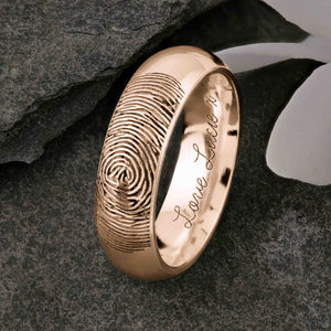 A unique rose Gold Wedding Ring with an engraved fingerprint on the outer surface | Engraved with a personalised handwritten message on the inside of the ring | The engraving reads "Love Lucie. x" | Contemporary Laser engraving | Mens 6mm wide, comfort court profile ring | Custom personalised wedding jewellery | Sophia Alexander Fingerprint Jewellery | Handmade in Suffolk UK