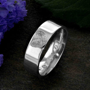 A Platinum Wedding Ring with two fingerprints engraved in the shape of a heart on the outer surface | Engraved with the word Forever on the inside of the ring | Set with a single diamond in the O of Forever | Hand engraving | Men's 6mm wide, comfort flat-court profile ring | Custom personalised wedding jewellery | Sophia Alexander Fingerprint Jewellery | Handmade in Suffolk UK