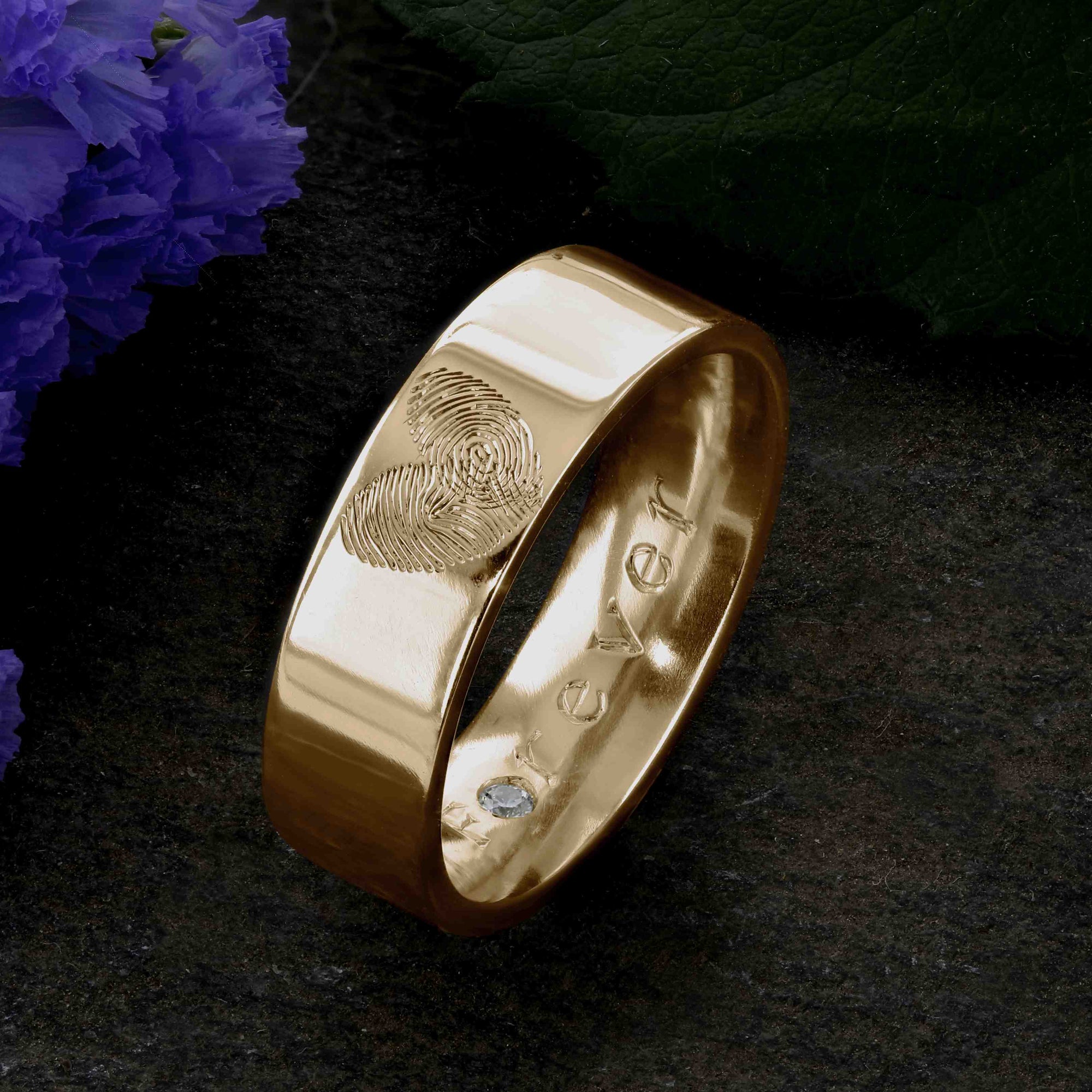 A Gold Wedding Ring with two fingerprints engraved in the shape of a heart on the outer surface | Engraved with  the word Forever on the inside of the ring | Set with a single diamond in the O of Forever | Hand engraving | Men's 6mm wide, comfort flat-court profile ring | Custom personalised wedding jewellery | Sophia Alexander Fingerprint Jewellery | Handmade in Suffolk UK