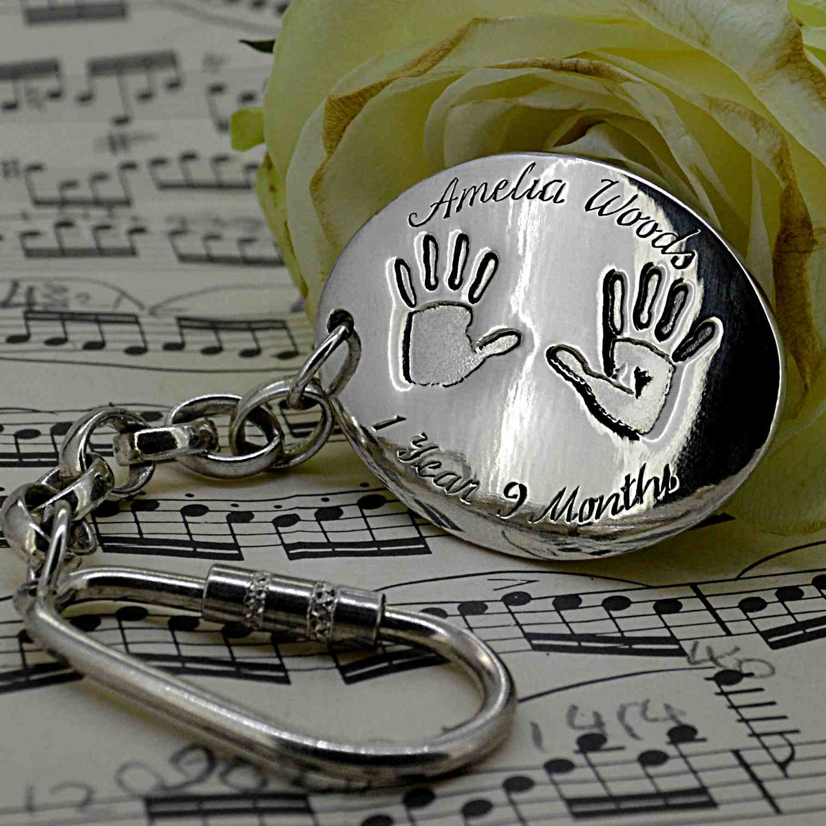 Large oval shaped Pendant in solid silver with two children's handprints | Engraved with a name and the child's age | Personalised Gift shown on a keyring with a chain | Sophia Alexander Fingerprint Jewellery | Handmade in Suffolk UK