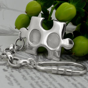 Solid silver puzzle piece style pendant with two children's fingerprints | Shown on a keyring with a chain | Personalised Gifts | Sophia Alexander Fingerprint Jewellery | Handmade in Suffolk UK